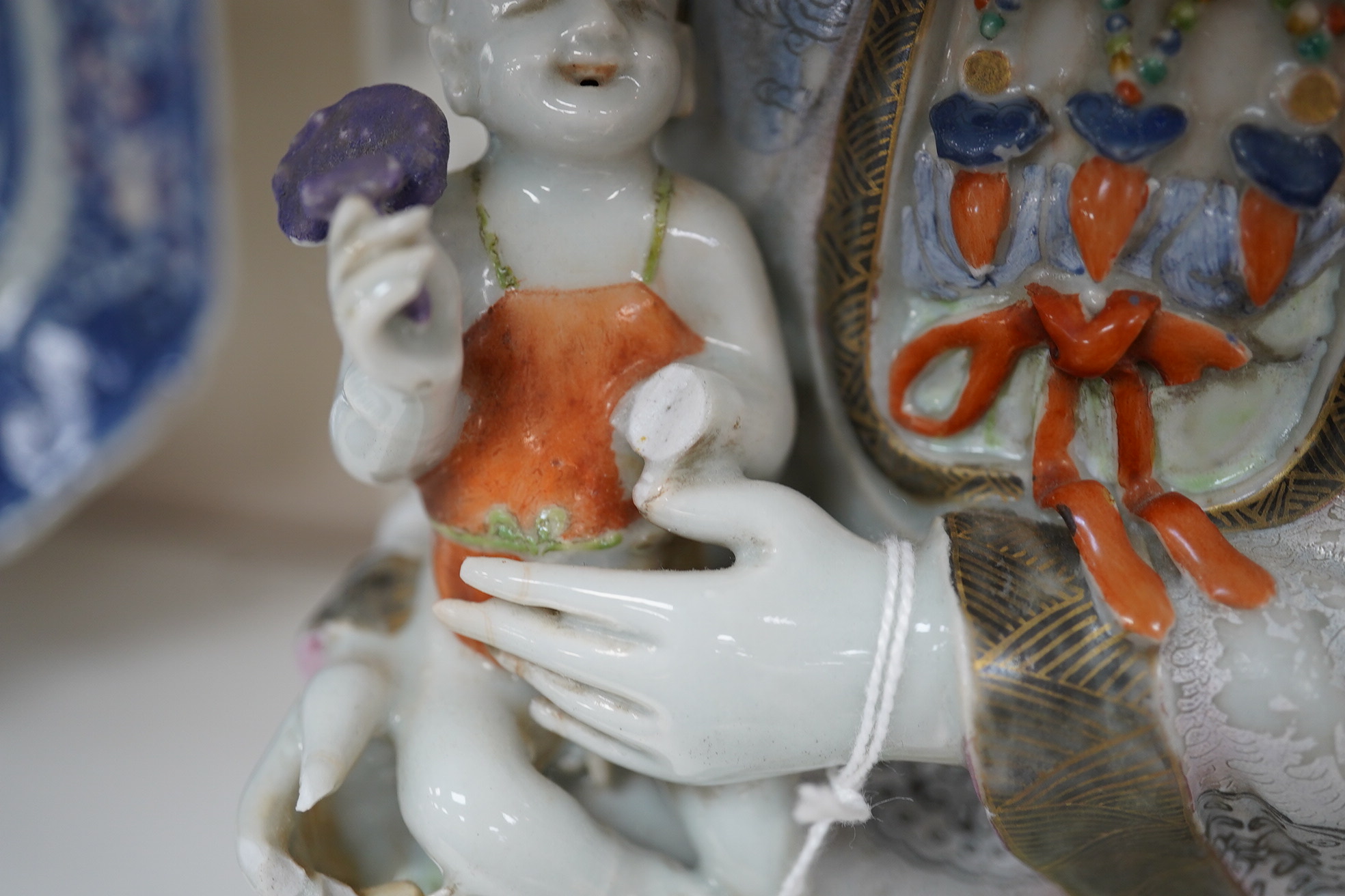 A Chinese enamelled porcelain group of Guanyin holding a child, Qianlong period